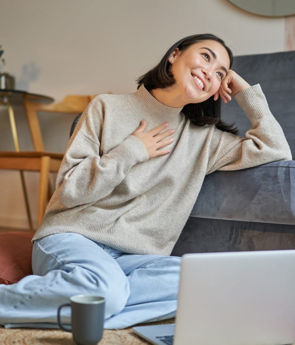 portrait-dreamy-woman-sitting-with-laptop-floor-watching-computer-drinking-coffee-enjoy-scaled.jpg